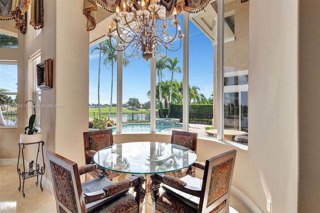 sunroom / solarium with a water view and a notable chandelier