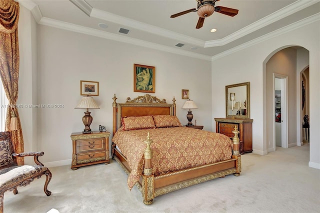 carpeted bedroom with a raised ceiling, ceiling fan, and crown molding