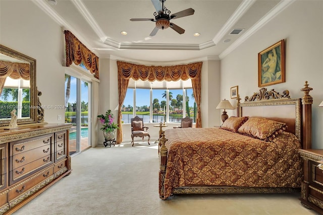 carpeted bedroom featuring access to outside, a raised ceiling, ceiling fan, crown molding, and a water view