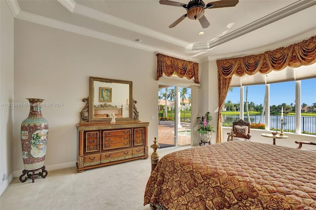 bedroom with light carpet, a raised ceiling, a water view, ceiling fan, and ornamental molding