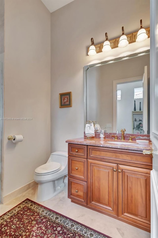 bathroom featuring tile patterned flooring, vanity, and toilet