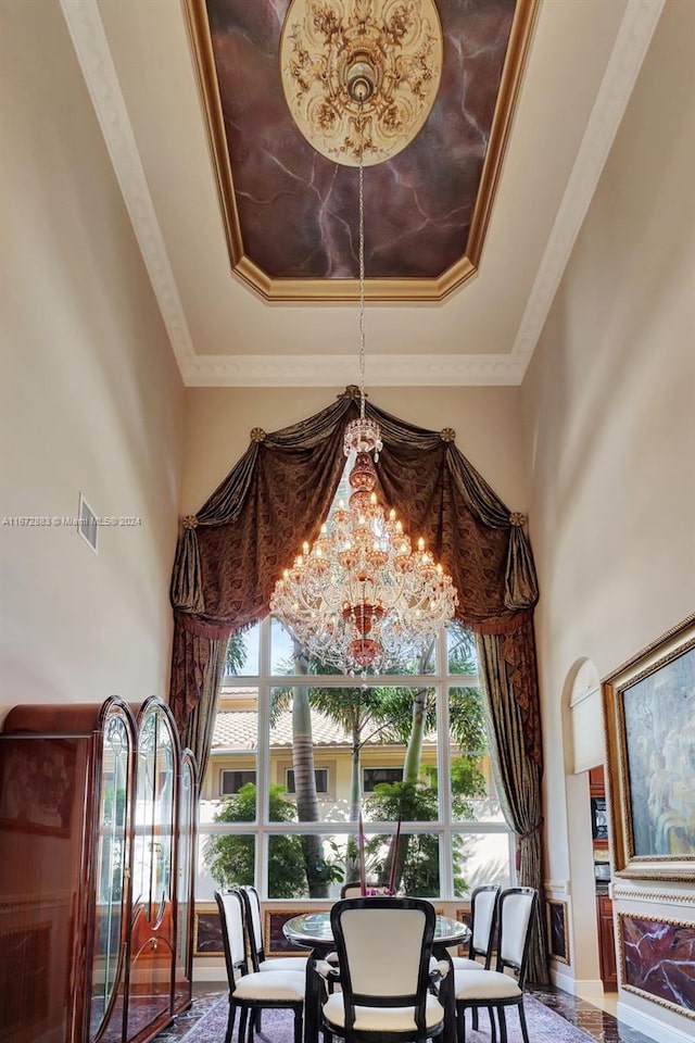 dining room with a tray ceiling, crown molding, and a chandelier