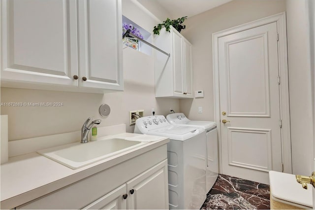 laundry room featuring cabinets, washer and clothes dryer, and sink