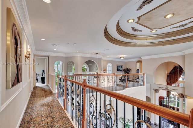 hall featuring a raised ceiling and crown molding