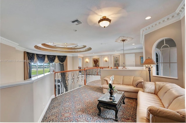 living room with a tray ceiling and ornamental molding