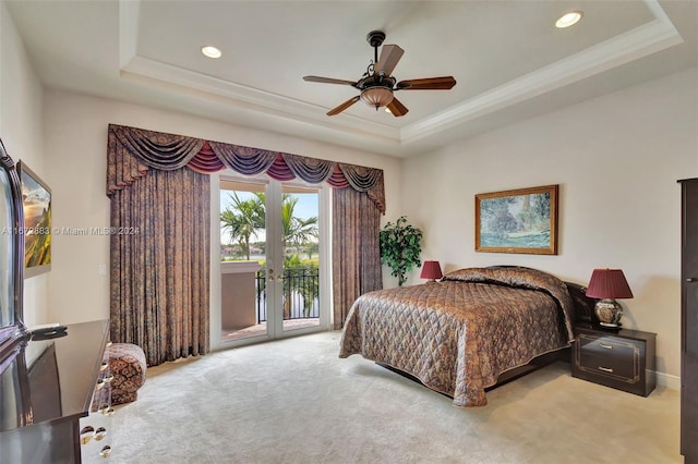 bedroom featuring carpet, ceiling fan, access to exterior, and a tray ceiling