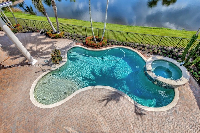 view of swimming pool with an in ground hot tub, a water view, and a patio area