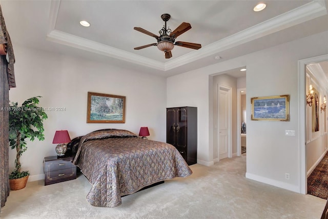 bedroom featuring ceiling fan, light colored carpet, ornamental molding, and a tray ceiling