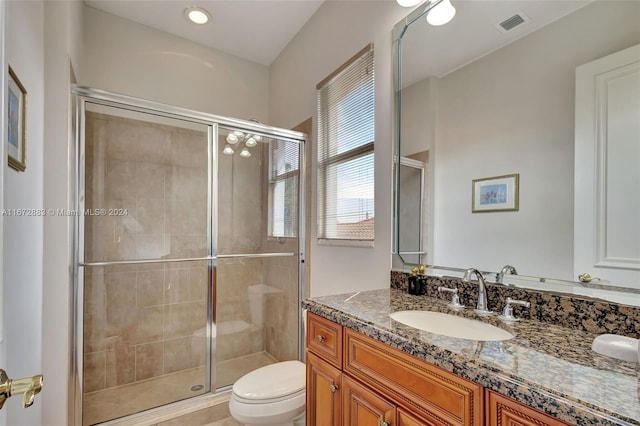 bathroom featuring vanity, toilet, and an enclosed shower