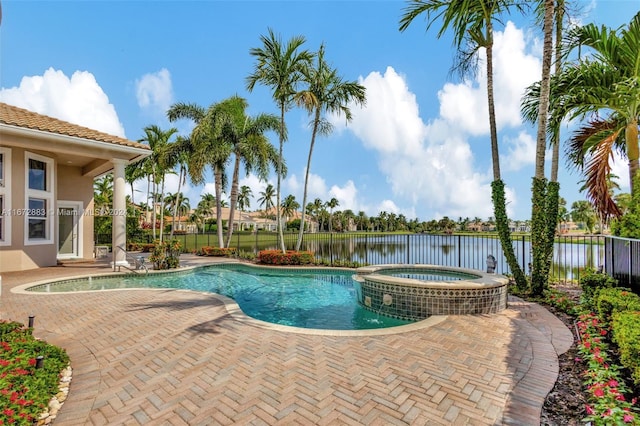 view of swimming pool with a water view and an in ground hot tub