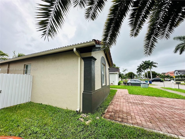 view of side of home featuring a yard and a patio