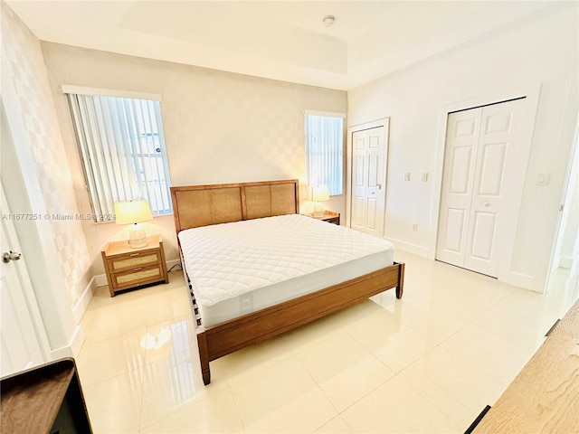 bedroom featuring light tile patterned floors and multiple closets