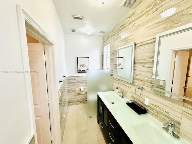 bathroom featuring tile patterned flooring, vanity, backsplash, and tile walls