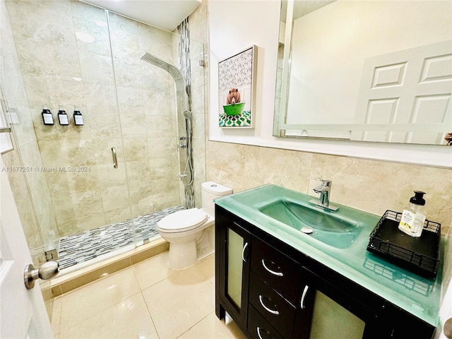 bathroom featuring walk in shower, tile patterned flooring, toilet, vanity, and tile walls