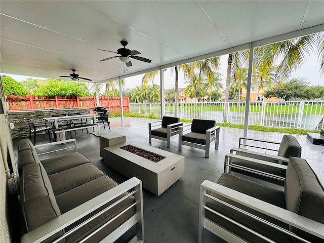 view of patio featuring a water view, an outdoor living space with a fire pit, and ceiling fan