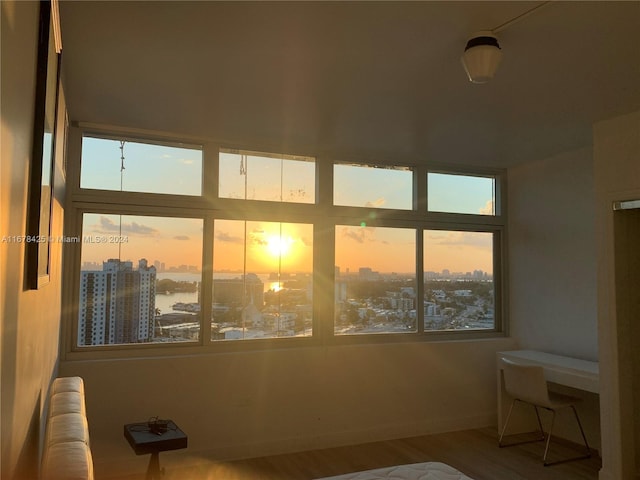 unfurnished bedroom with hardwood / wood-style floors, a water view, and radiator