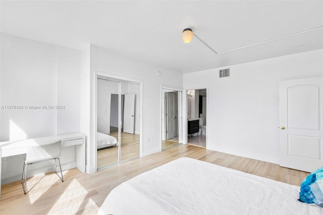 bedroom featuring hardwood / wood-style flooring and connected bathroom