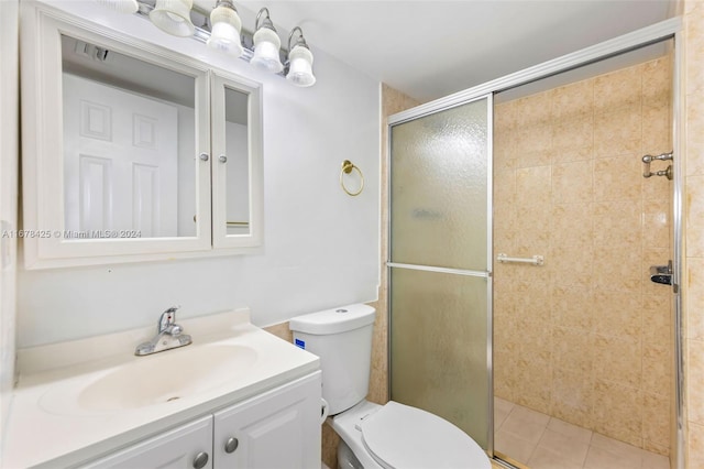 bathroom with tile patterned flooring, vanity, toilet, and an enclosed shower