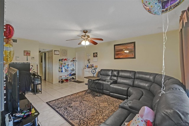 living room with ceiling fan, a textured ceiling, and light tile patterned floors