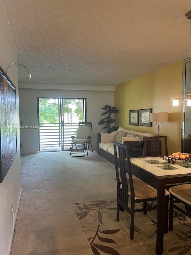 carpeted dining room with a textured ceiling