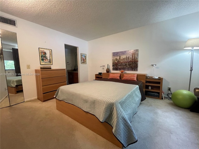bedroom featuring baseboards, visible vents, a textured ceiling, and light colored carpet