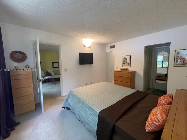 bedroom with light carpet and a textured ceiling