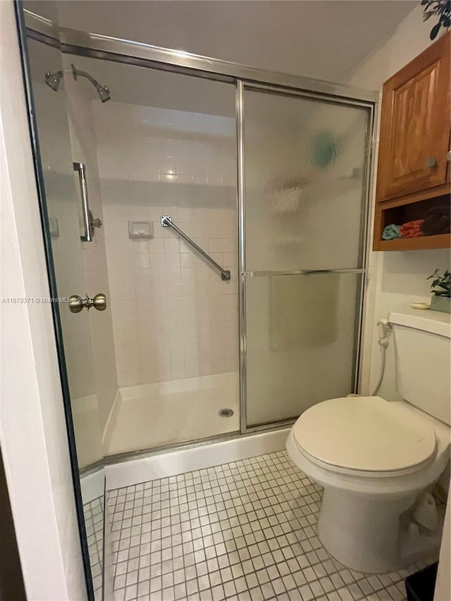 full bathroom featuring tile patterned flooring, a stall shower, and toilet