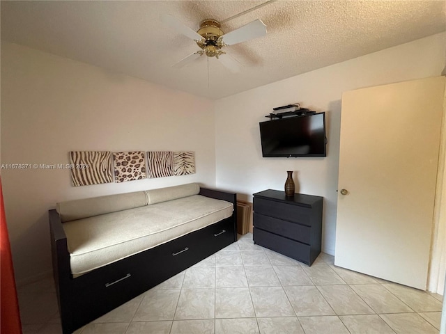 sitting room featuring light tile patterned flooring, a textured ceiling, and ceiling fan