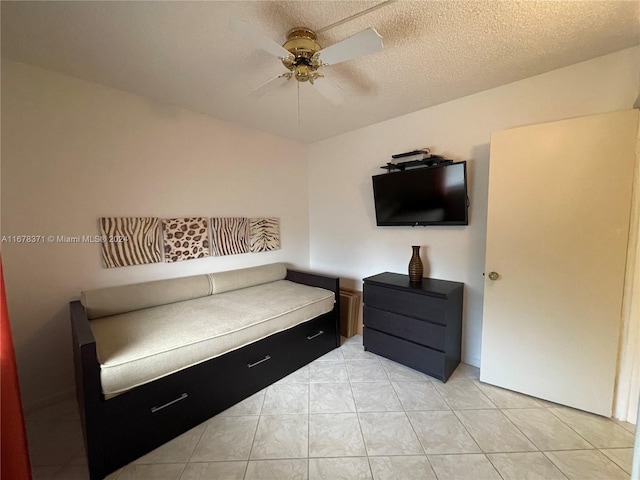 living area featuring a textured ceiling, ceiling fan, and light tile patterned floors