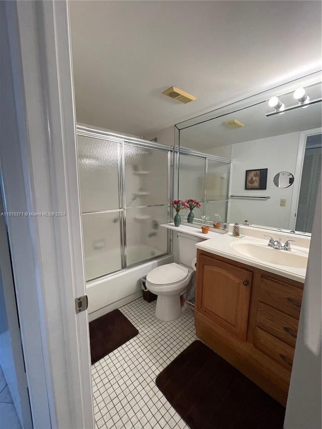 full bathroom featuring visible vents, tile patterned flooring, vanity, combined bath / shower with glass door, and toilet