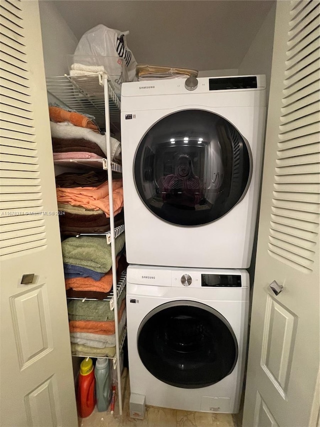 clothes washing area with laundry area and stacked washer and dryer