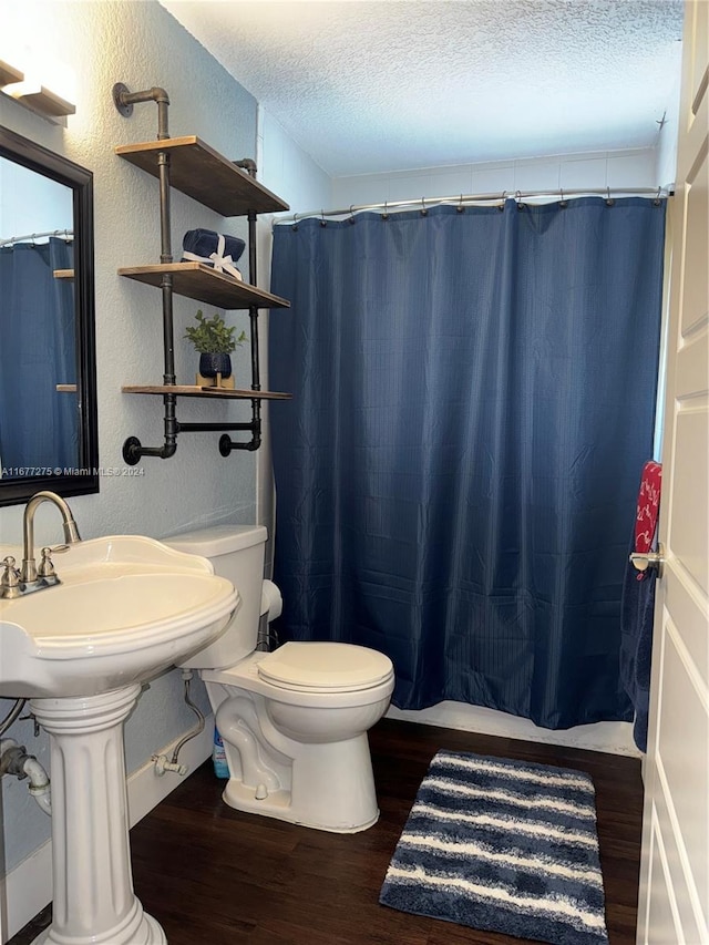 bathroom featuring hardwood / wood-style floors, a textured ceiling, toilet, and walk in shower