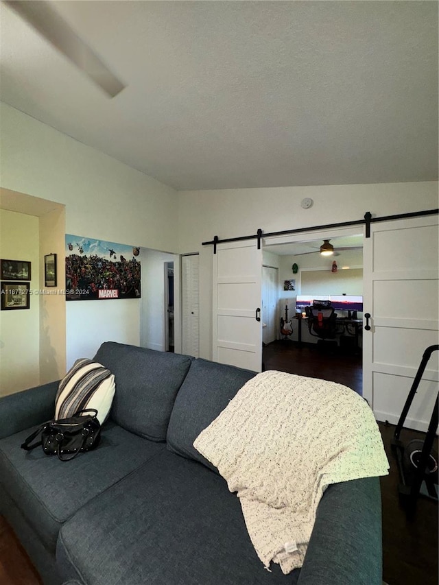 bedroom featuring dark hardwood / wood-style floors, vaulted ceiling, and a barn door