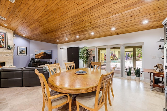 dining space featuring french doors, a large fireplace, wood ceiling, and vaulted ceiling