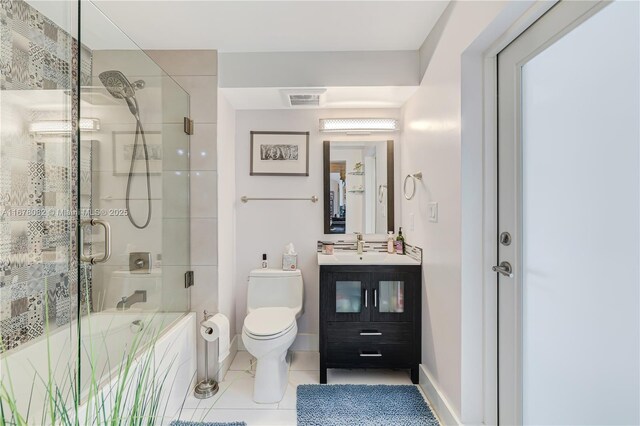 bathroom with an enclosed shower, vanity, tile patterned floors, and toilet