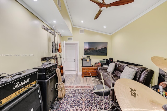 living room featuring crown molding, ceiling fan, light hardwood / wood-style floors, and vaulted ceiling