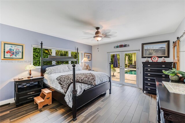 bedroom with hardwood / wood-style flooring, access to exterior, ceiling fan, a barn door, and french doors