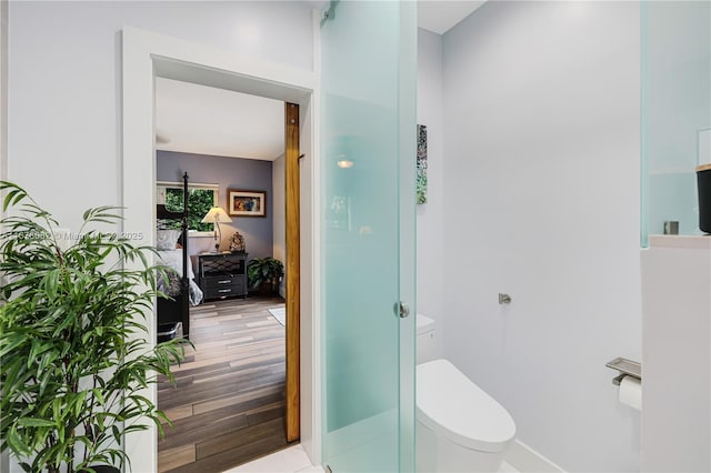 bathroom with hardwood / wood-style flooring and toilet