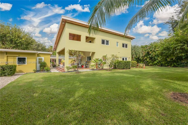 back of property with a yard and a patio area