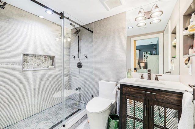 bathroom featuring vanity, toilet, and a shower with shower door