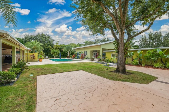 view of pool with a lawn and a patio area