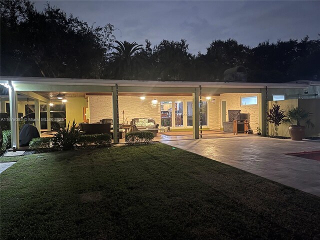 back of house with an outdoor living space, a patio, and a yard