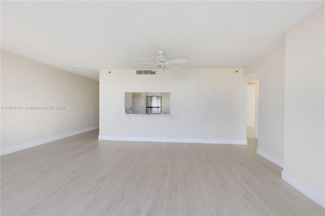 empty room with light hardwood / wood-style flooring and ceiling fan