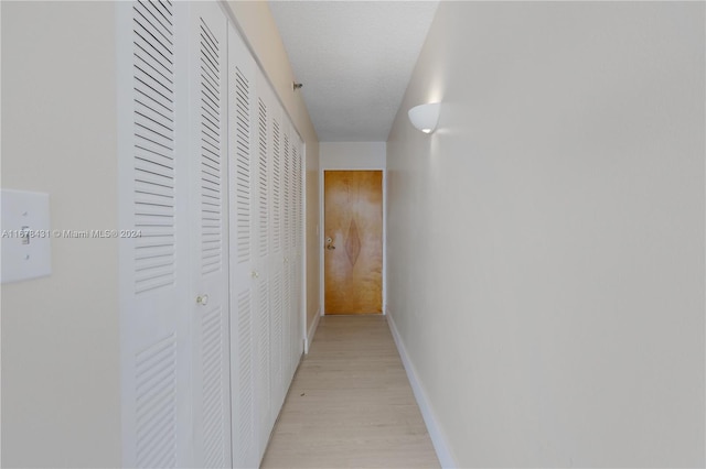 hallway featuring a textured ceiling and light wood-type flooring