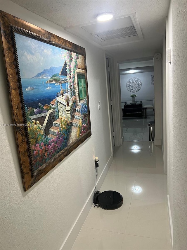 hallway featuring tile patterned floors and a textured ceiling