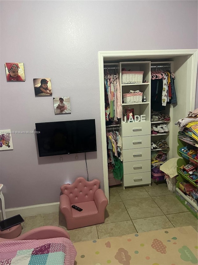 tiled bedroom with a closet