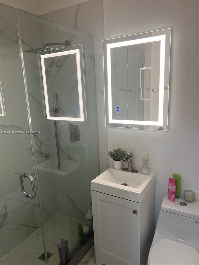 bathroom featuring vanity, an enclosed shower, and toilet