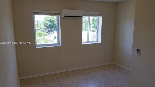 tiled empty room with a wall mounted air conditioner and a healthy amount of sunlight