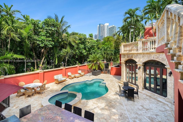 view of pool featuring a patio, french doors, and an in ground hot tub