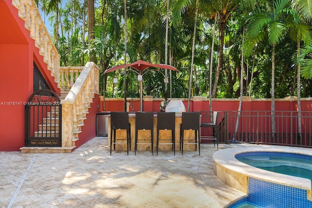 view of patio / terrace with an in ground hot tub and exterior bar